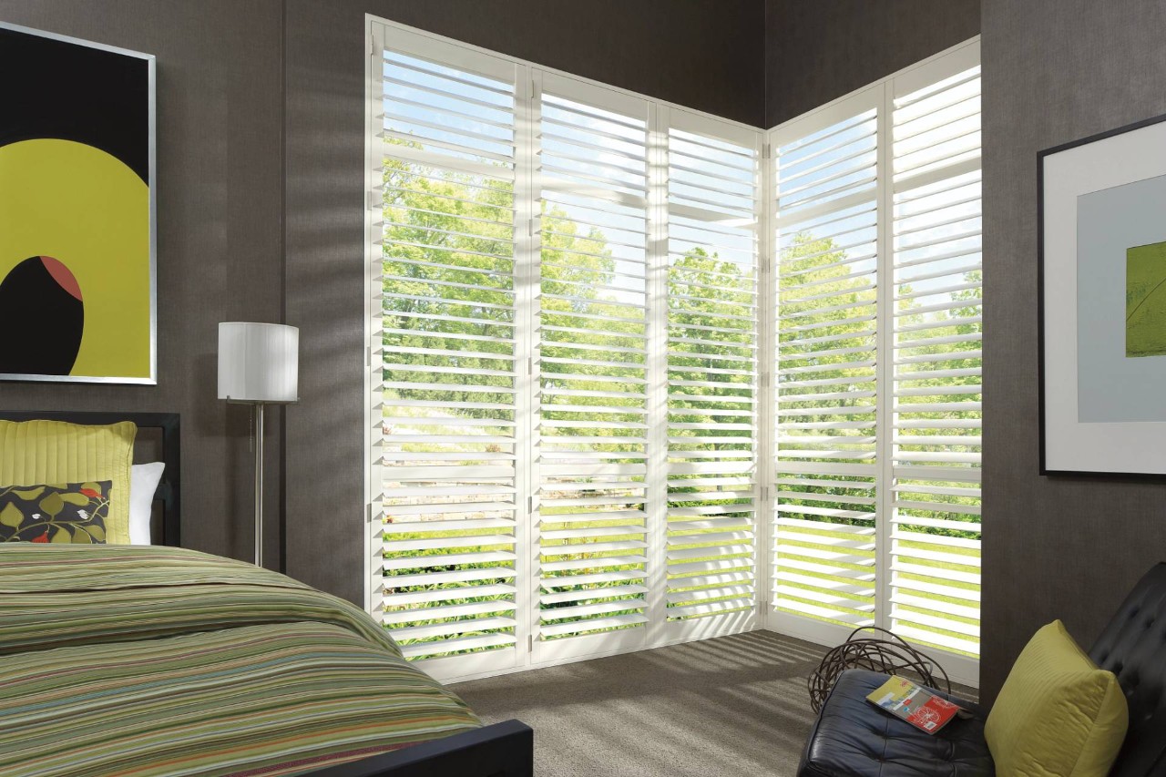 Hunter Douglas composite shutters filtering light into a contemporary bedroom near Silver Springs, MD